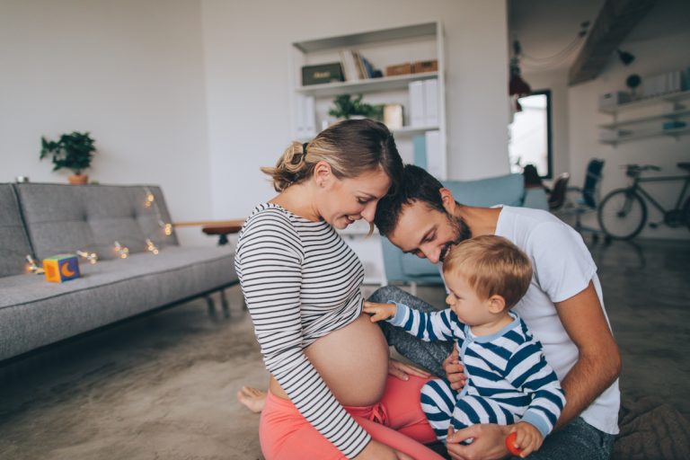 Photo of a little boy being curious about his mother's growing belly