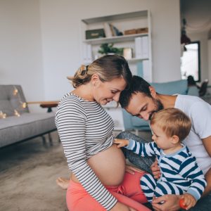 Photo of a little boy being curious about his mother's growing belly